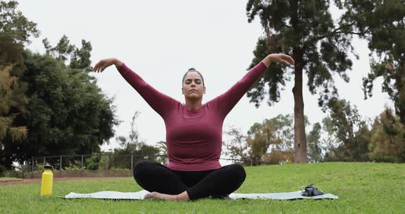 Young curvy woman doing yoga exercise outdoor alt