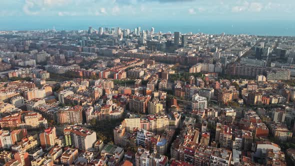 Aerial drone view of Barcelona, Spain. Blocks with multiple residential buildings, Mediterranean sea alt
