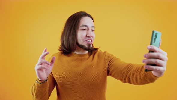 Excited Bearded Caucasian Man Talking Over a Smartphone Video Chat alt