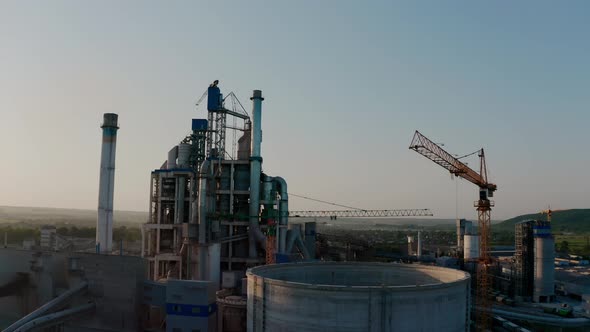Cement Plant with High Factory Structure at Industrial Production Area at Sunset alt