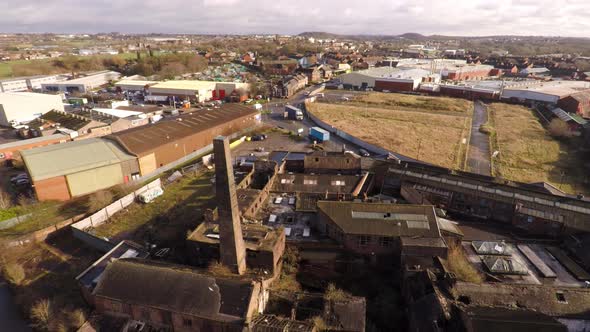 Aerial footage of an old abandoned, derelict pottery factory and bottle kiln located in Longport, St alt