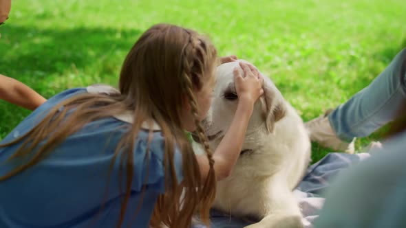 Cute Girl Hugging Labrador on Park Picnic alt