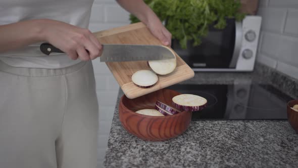 Girl Slicing Eggplant On Cutting Board In The Kitchen alt