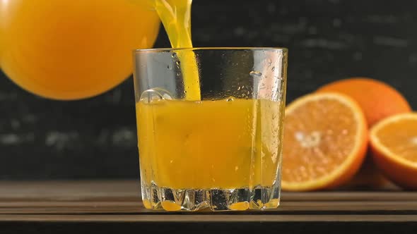 Orange Juice Pouring in Glass with Ice Cubes and Water Drops alt