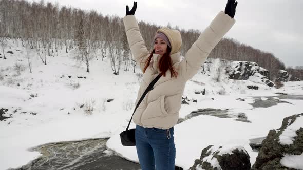 Sporting a Young Girl Rejoices and Whirls on Top of a Snowy Mountain