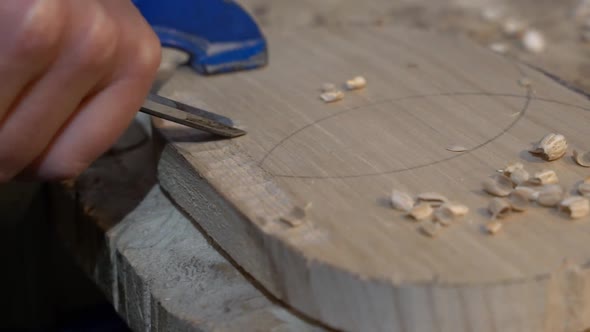 Chiseling wood blank with design pattern to make a furniture décor piece, Close up shot alt