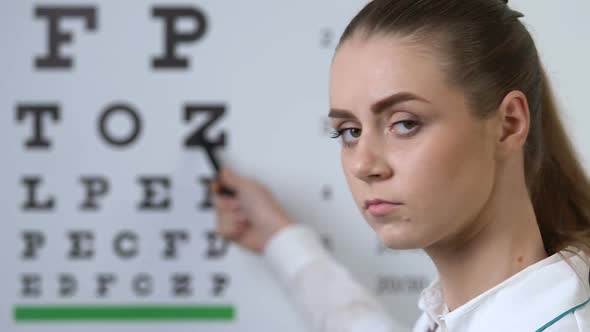 Professional Female Oculist Pointing at Letter on Chart, Farsightedness Disease alt