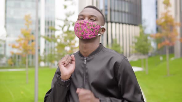 A Young Black Man in a Face Mask Dances and Looks at the Camera - Office Buildings