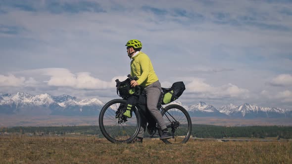 The Man Travel on Mixed Terrain Cycle Touring with Bikepacking. The Traveler Journey with Bicycle alt