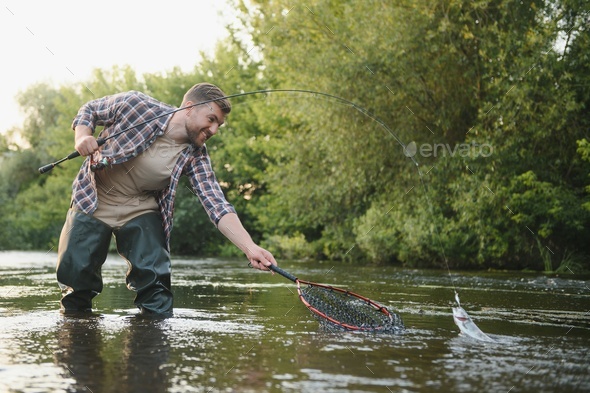 Person fishing a fish with a rod Stock Photo