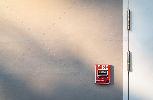 Fire alarm on dark gray concrete wall. Warning and security system. Emergency equipment for safety