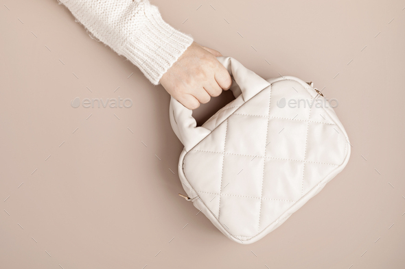 Beige quilted puffed bag on pastel background