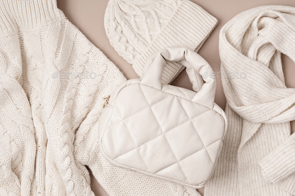 Beige quilted puffed bag and woolen accessories on pastel background