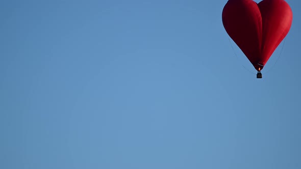 Colorful Hotair Heart Shape Balloon Flying on Sunset Over Blue Sky in Slow Motion Happy Valentines alt
