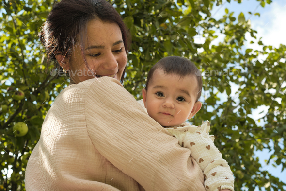 Embodying the essence of health and vitality, a mother holds her one-year-old with love, surrounded