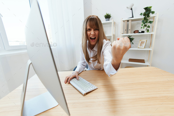 Angry evil blonde businesswoman screaming to subordinates shaking fist at camera sitting at