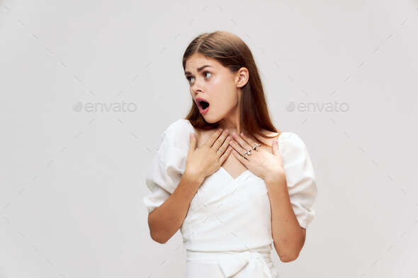 Emotional surprised woman holds hands in front of her open mouth look in side