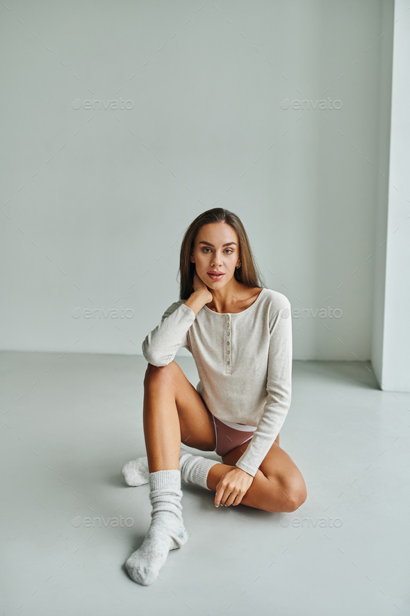 beautiful young woman in socks, panties and long sleeve shirt sitting on  floor at home, long hair Stock Photo by LightFieldStudios