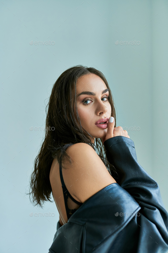 portrait of seductive woman with wet brunette hair posing in black lace  underwear, touching lip Stock Photo by LightFieldStudios