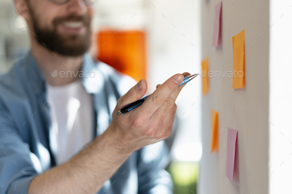 Close-up hands of a successful manager using sticky notes, agile methodology. Scrum concept