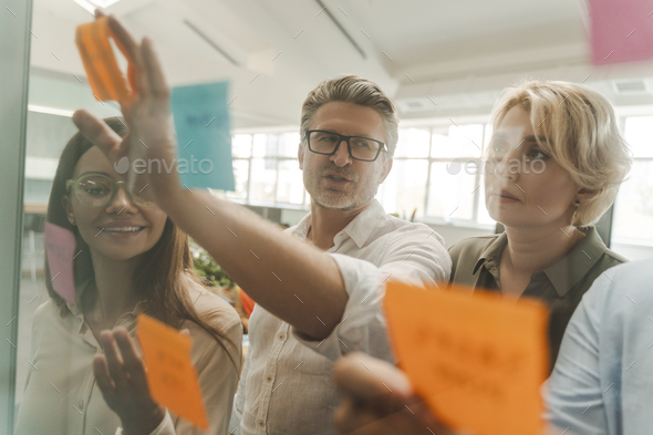 Business people using sticky notes, agile methodology for productivity working in modern office