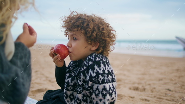Little boy resting picnic at autumn beach closeup. Cheerful kid having fun