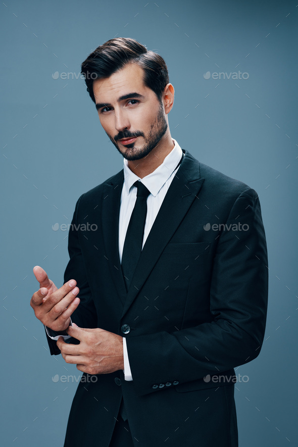 Handsome male with beard, dressed in formal suit, poses outdoor, has watch  on arm, being in high spirit after successfully signed contract, feels  confident and pleased. Prosperous businessman smiles 11565478 Stock Photo