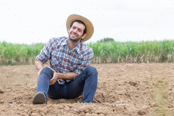 The farmer had cramps in his legs and had a pained expression on his face.