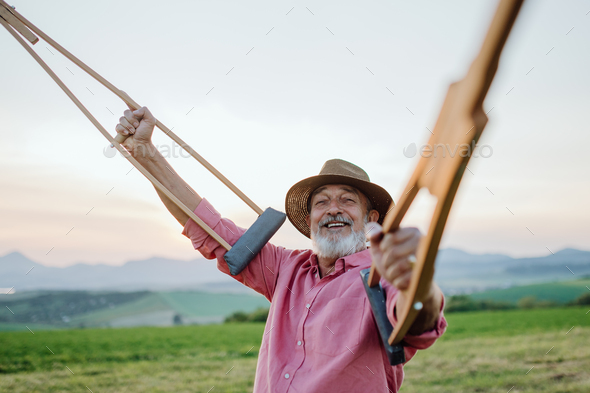 Senior man holding crutches in the air. Recovery, rehabilitation after injury or surgery in the