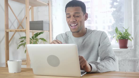Video Chat By Young AfroAmerican Man in Office on Laptop alt