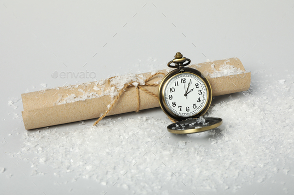 Pocket watch with snow on a light background. Stock Photo by