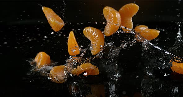 Clementines, citrus reticulata, Fruits falling on Water against black Background, Slow Motion 4K alt