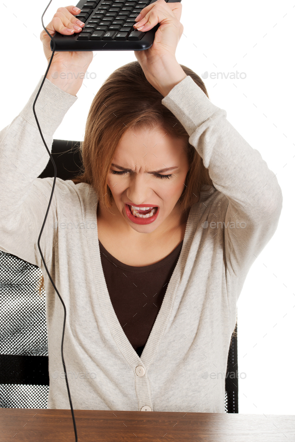 Blonde Caucasian woman throwing her keyboard with an angry face