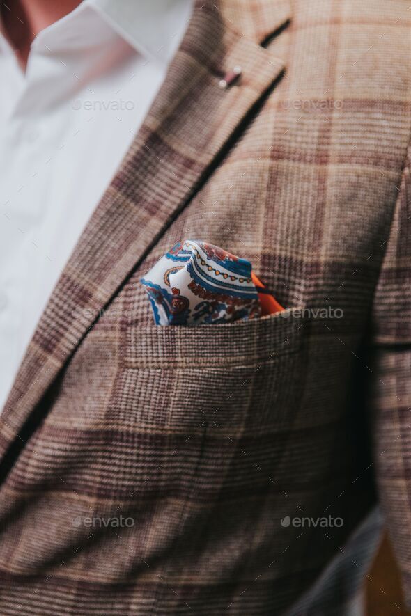 Vertical shot of a man\'s brown check suit jacket with a paisley pocket square