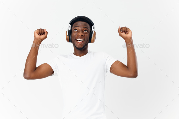 African American with a satisfied expression on his face in headphones listens to music in a dance