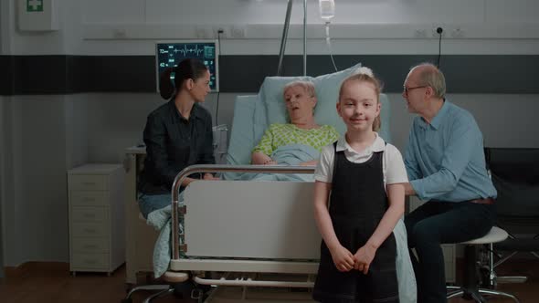 Portrait of Kid in Hospital Ward Visiting Aged Patient in Bed alt