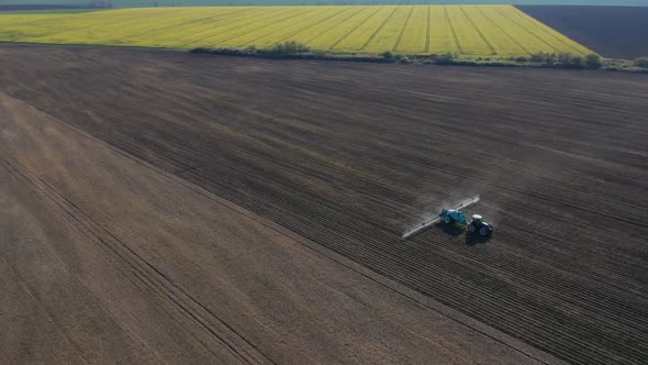 Aerial view of a tractor that irrigates agricultural field alt
