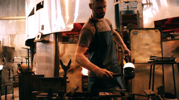 Glassblower shaping a molten glass alt