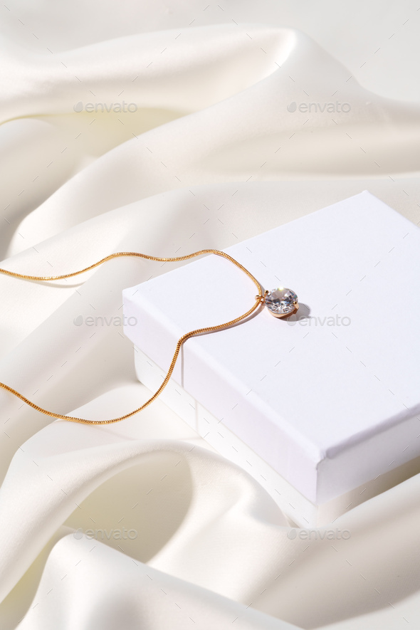 Golden chain in jewel box on silk background