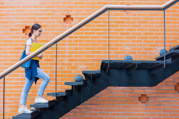 University student walk climb stairs step up in school campus to rise higher success smart woman