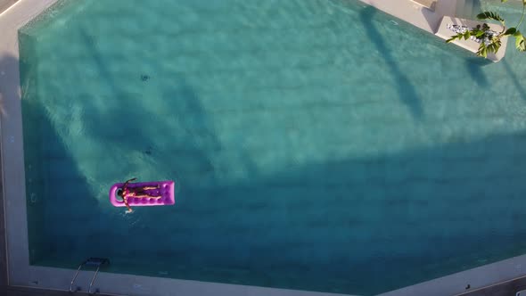 Little Girl Floats on an Inflatable Mattress in the Pool