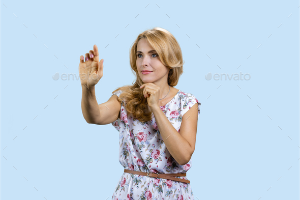 Portrait of blonde woman zooms in something on an invisible imaginary virtual screen.