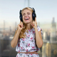 Happy blonde middle aged woman listening to music in headphones with closed eyes. - PhotoDune Item for Sale