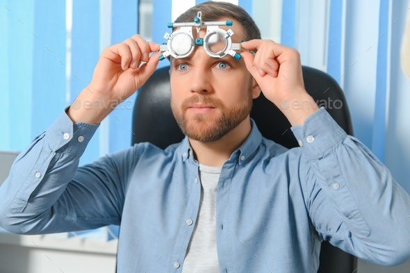 Handsome young man is checking the eye vision in modern ophthalmology clinic
