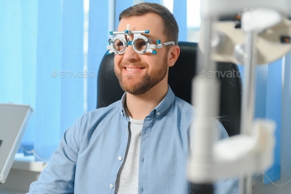 Handsome young man is checking the eye vision in modern ophthalmology clinic.
