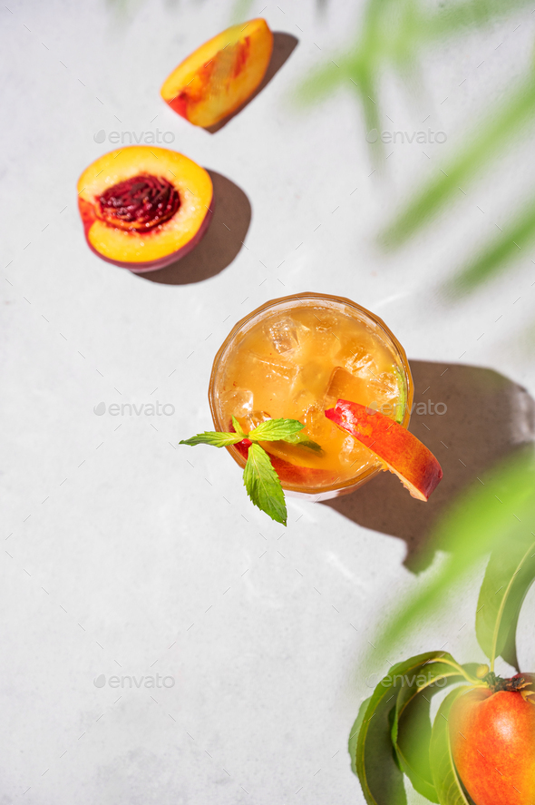 Refreshing peach tea with ice and mint. Homemade cold healthy drink on a light background