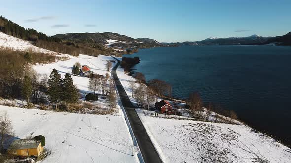 Coastal Road Surrounded With Snowy Landscape During Winter In Norway. aerial alt