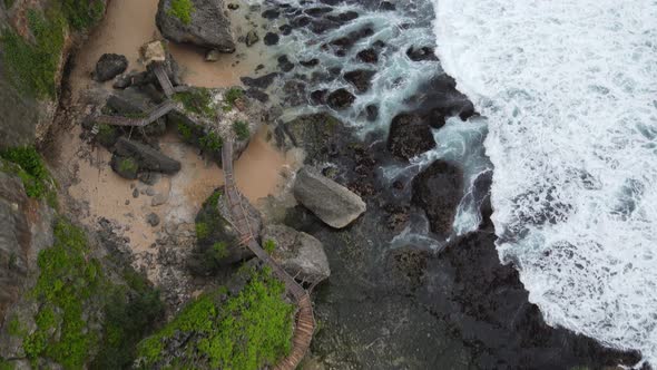 Top down aerial view of giant ocean waves crashing and foaming in coral beach alt