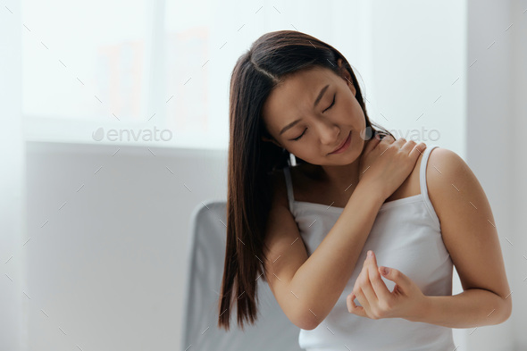 Suffering from shoulder dislocation neuralgia tanned beautiful young Asian woman touching painful