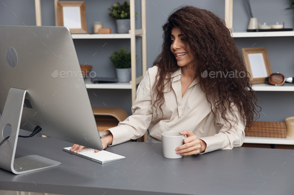 Love what you do concept. Joyful tanned adorable curly Latin businesswoman in linen shirt smiling